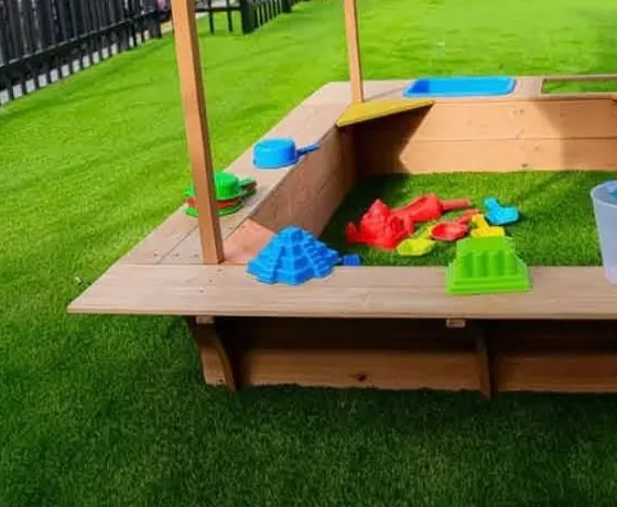 Buckets, spades and sand moulds in the covered timber sandpit