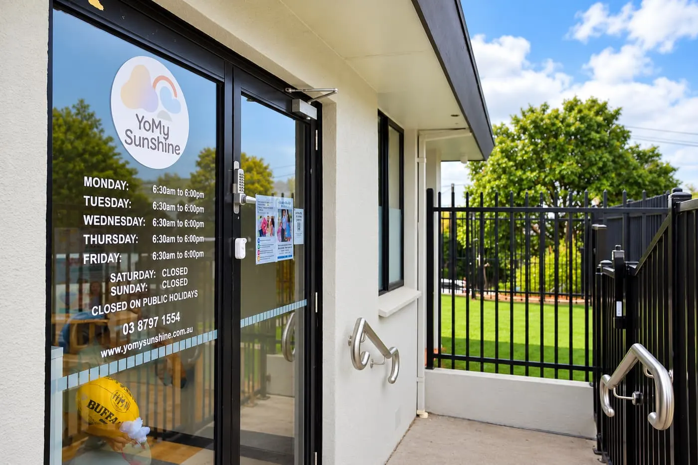 Front entrance of YoMy Sunshine, with the daily hours listed on the door
